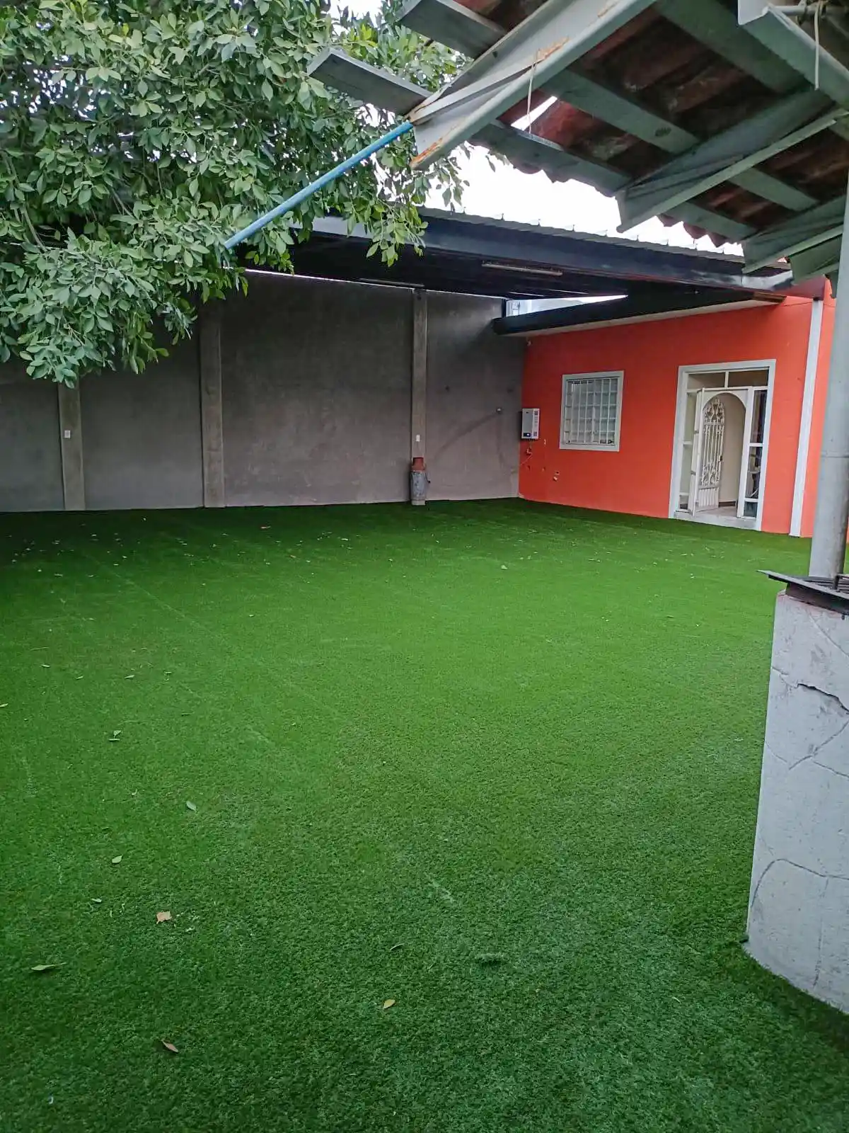 Patio residencial renovado con pasto sintético