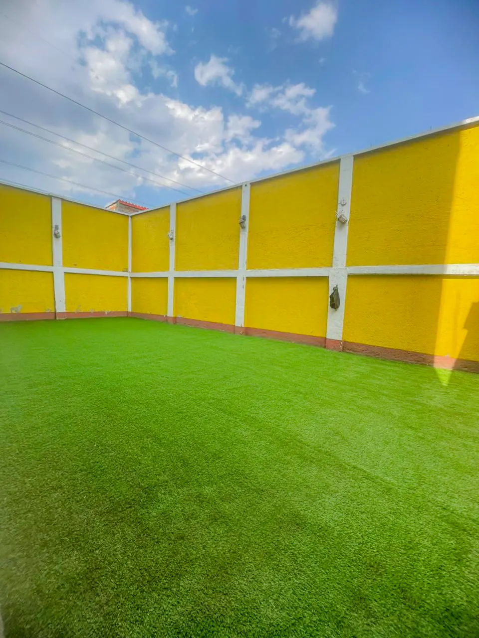 Jardín residencial terminado con pasto sintético