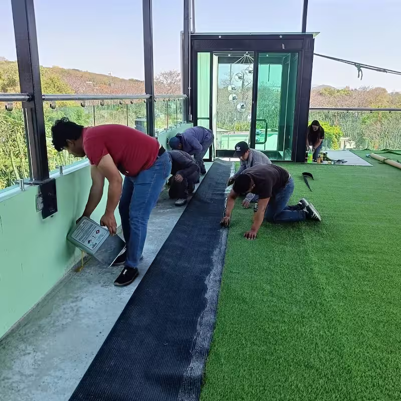 Equipo de Decostore instalando pasto sintético residencial